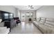 Bright living room features tile floors, a ceiling fan, and a comfortable, modern reclining sofa at 1811 Redmond Brook Ln, Ruskin, FL 33570