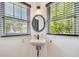 Charming bathroom with stylish sconce and round mirror above floating sink at 233 24Th N St, St Petersburg, FL 33713