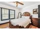 Traditional bedroom with hardwood floors, ornate bed frame, ceiling fan, and natural light from the window at 233 24Th N St, St Petersburg, FL 33713
