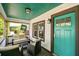 Cozy covered front porch with stylish seating, a bright turquoise door, and a 'Historic Kenwood' sign at 233 24Th N St, St Petersburg, FL 33713