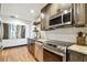 Modern kitchen featuring stainless steel appliances, granite countertops, subway tile backsplash and warm wood floors at 233 24Th N St, St Petersburg, FL 33713