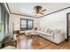 Bright living room featuring hardwood floors, a comfortable sectional sofa, and a modern ceiling fan at 233 24Th N St, St Petersburg, FL 33713