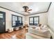 Sunlit living room with hardwood floors, a large sectional sofa, and classic dark-trimmed windows and door at 233 24Th N St, St Petersburg, FL 33713