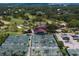 A high angle view shows tennis courts and a golf course along with a clubhouse and parking area at 2665 Clubhouse N Dr, Clearwater, FL 33761