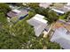 This aerial view highlights the roof, neighboring pool, mature trees, and community at 2665 Clubhouse N Dr, Clearwater, FL 33761