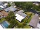 The aerial view showcases the roof, backyard with lush greenery, mature trees, and a peek at the pool at 2665 Clubhouse N Dr, Clearwater, FL 33761