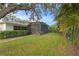 Beautiful backyard featuring a screened-in lanai, tropical foliage, and a manicured lawn at 2665 Clubhouse N Dr, Clearwater, FL 33761