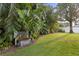 Lush backyard featuring tropical plants, a modern water feature, and a well-maintained lawn at 2665 Clubhouse N Dr, Clearwater, FL 33761