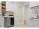 Bright Butler Pantry with floating shelves, stainless beverage center and white quartz counter at 2665 Clubhouse N Dr, Clearwater, FL 33761