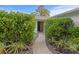Lush shrubs line the walkway to the front door of this lovely home at 2665 Clubhouse N Dr, Clearwater, FL 33761