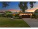 Beautiful single-story home featuring a two-car garage, lush landscaping, and a well-manicured lawn at sunset at 2665 Clubhouse N Dr, Clearwater, FL 33761