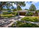 Charming single-story home with a two-car garage, well-maintained lawn, and tree-lined street at 2665 Clubhouse N Dr, Clearwater, FL 33761