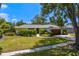 Well-maintained home features lush landscaping, a dark wood garage door, and a sidewalk to the entrance at 2665 Clubhouse N Dr, Clearwater, FL 33761