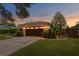 Charming home with a dark brown garage door, beautiful landscaping, and exterior lighting at 2665 Clubhouse N Dr, Clearwater, FL 33761