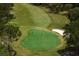 Scenic golf course aerial highlighting manicured green with players, framed by trees and sand bunkers at 2665 Clubhouse N Dr, Clearwater, FL 33761