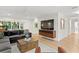 Bright, open living room with hardwood floors, a modern sectional sofa, and a mounted TV at 2665 Clubhouse N Dr, Clearwater, FL 33761