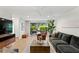 Bright living room with hardwood floors, modern furnishings, and large window with beautiful backyard view at 2665 Clubhouse N Dr, Clearwater, FL 33761