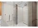 Modern shower featuring white tile, glass door, and gray accent column at 2665 Clubhouse N Dr, Clearwater, FL 33761