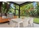 Outdoor patio with stainless steel grill, dining table, and lush tropical landscaping at 2665 Clubhouse N Dr, Clearwater, FL 33761