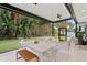 Covered patio with dining and lounging areas overlooking a lush backyard at 2665 Clubhouse N Dr, Clearwater, FL 33761