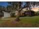 This home features mature landscaping, a screened in porch, and modern exterior design at 2665 Clubhouse N Dr, Clearwater, FL 33761