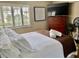 Inviting bedroom features a TV, dresser, and sun-drenched window with classic white shutters at 29129 Bay Hollow Dr # 3201, Wesley Chapel, FL 33543