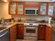 Modern kitchen with stainless steel appliances, granite countertops, and wooden cabinetry is equipped for modern cooking at 29129 Bay Hollow Dr # 3201, Wesley Chapel, FL 33543