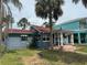 Charming single-story home featuring a red roof, quaint front porch, and tropical landscaping at 3007 Clinton S St, Gulfport, FL 33707