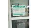 Close-up of a window with a taped inspection notice indicating approval at 3007 Clinton S St, Gulfport, FL 33707