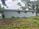 Rear view of the home, showing the exterior, roofline, and windows against a green yard at 310 2Nd Nw Ave, Ruskin, FL 33570