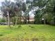Expansive backyard with lush green grass, mature trees, and tropical foliage at 310 2Nd Nw Ave, Ruskin, FL 33570