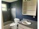 Functional bathroom with a tub, toilet, vanity, and wall-mounted storage at 310 2Nd Nw Ave, Ruskin, FL 33570