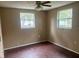 Cozy bedroom featuring hardwood floors, ceiling fan, and two windows offering ample natural light at 310 2Nd Nw Ave, Ruskin, FL 33570