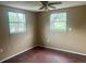 Bedroom featuring wood-look floors and ample natural light from two windows at 310 2Nd Nw Ave, Ruskin, FL 33570