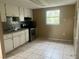 Functional kitchen with stainless steel appliances, tiled floor, and neutral cabinets at 310 2Nd Nw Ave, Ruskin, FL 33570