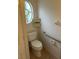 Cozy powder room with toilet, a corner cabinet, and a porthole window at 3145 Meta Ct, Largo, FL 33771