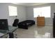 Minimalist bedroom with tiled floors, a dark bed, and a functional desk setup at 3424 Truman Dr, Holiday, FL 34691