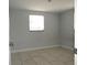 Simple bedroom featuring tile floors, light gray walls, and a window with natural light at 3424 Truman Dr, Holiday, FL 34691