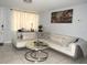 Cozy living room with modern white sofa, glass-top coffee table, and elegant decor at 3424 Truman Dr, Holiday, FL 34691