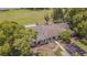 Aerial view of the property featuring mature trees, gardens, and carport at 35058 Whispering Oaks Blvd, Dade City, FL 33523