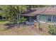 An outdoor view showcasing a covered lanai, green space and mature trees at 35058 Whispering Oaks Blvd, Dade City, FL 33523