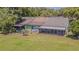 View of backyards with mature trees and screened-in patio offering outdoor living space at 35058 Whispering Oaks Blvd, Dade City, FL 33523
