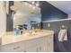 Bathroom with a mirror, vanity, sink, and dark blue walls at 35058 Whispering Oaks Blvd, Dade City, FL 33523