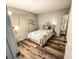 Cozy bedroom featuring wood-look floors, an ornate bed frame, and natural light at 35058 Whispering Oaks Blvd, Dade City, FL 33523