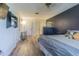 Bedroom with laminate flooring, dark blue accent wall, bed, and overhead lighting at 35058 Whispering Oaks Blvd, Dade City, FL 33523