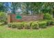 Welcoming brick sign for Whispering Oaks Estates Golf and Country Club with lush landscaping at 35058 Whispering Oaks Blvd, Dade City, FL 33523