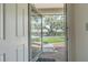 View of the front yard from the open front door and storm door at 35058 Whispering Oaks Blvd, Dade City, FL 33523