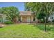 Charming brick home with a well-manicured lawn and a cozy front porch seating area at 35058 Whispering Oaks Blvd, Dade City, FL 33523