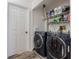 Functional laundry room features modern washer and dryer and overhead shelving at 35058 Whispering Oaks Blvd, Dade City, FL 33523
