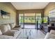 Living room featuring a couch, television, and view of the back yard at 35058 Whispering Oaks Blvd, Dade City, FL 33523